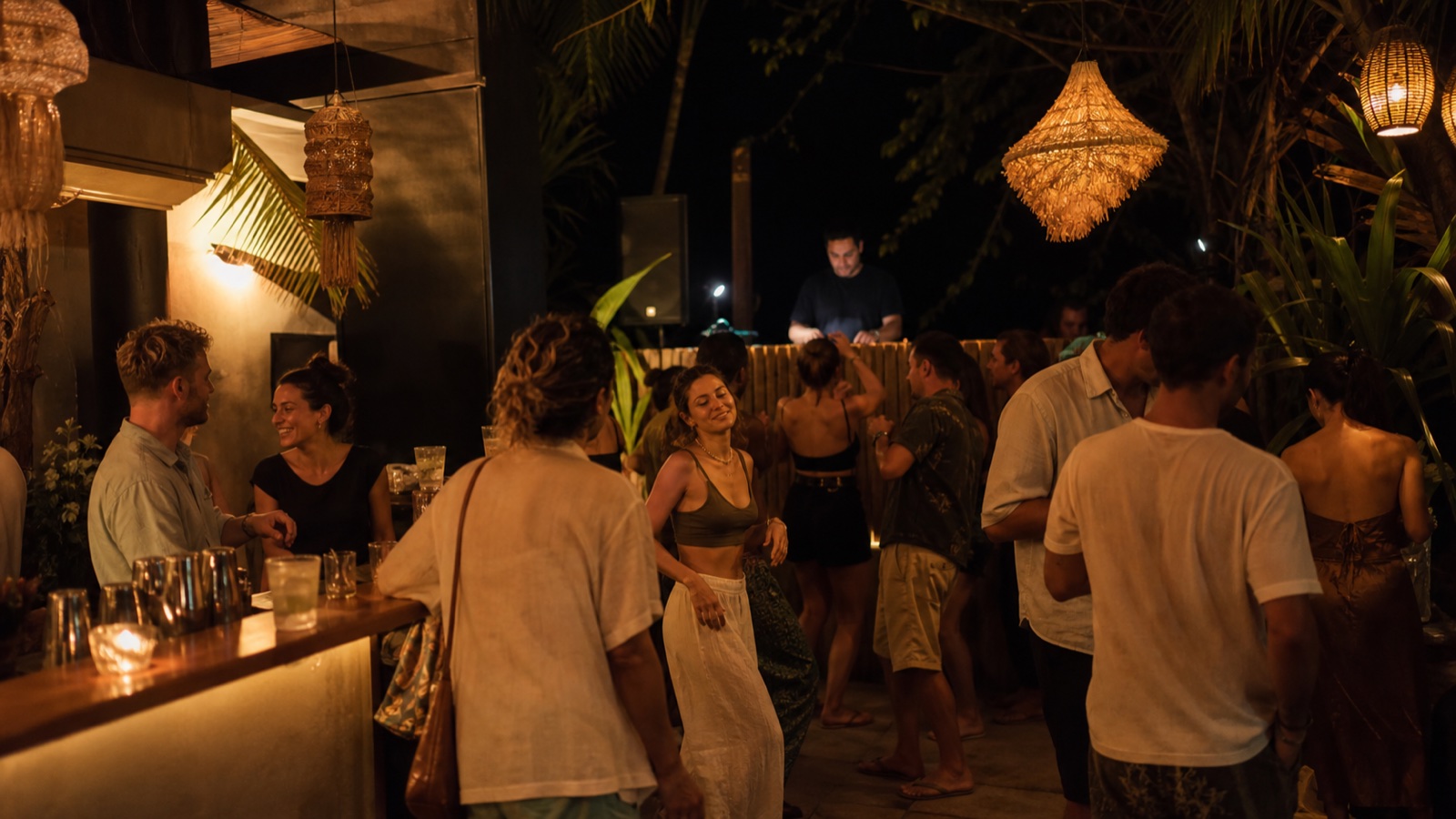 Adults socializing and dancing at an intimate open-air tropical bar in Santa Teresa