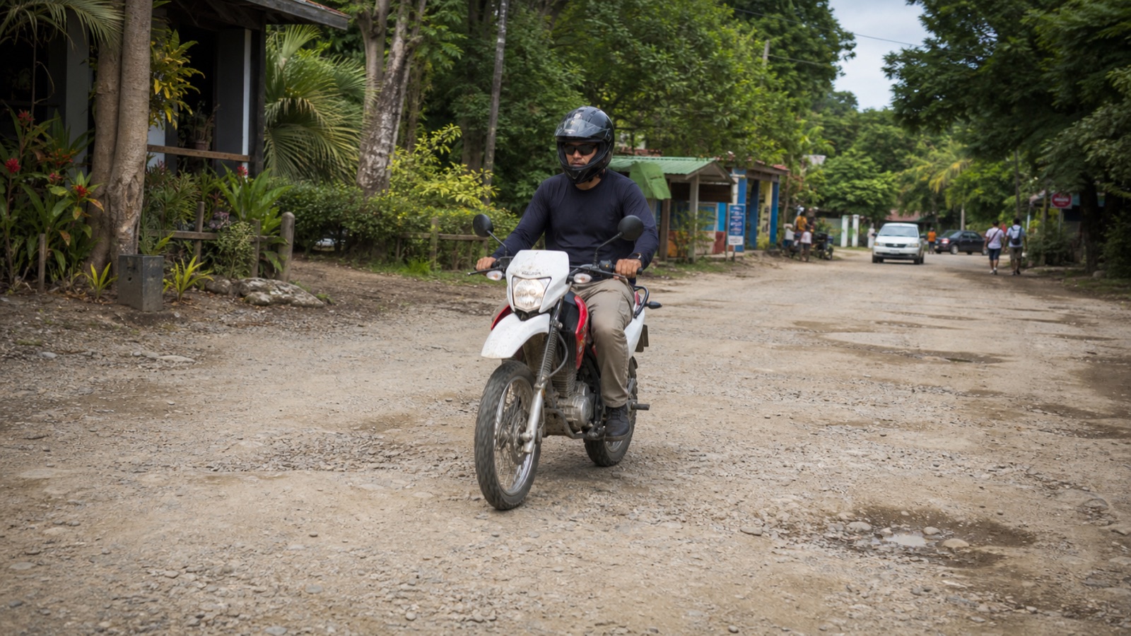 Helmeted motorcyclist riding conservatively on an uneven Santa Teresa road