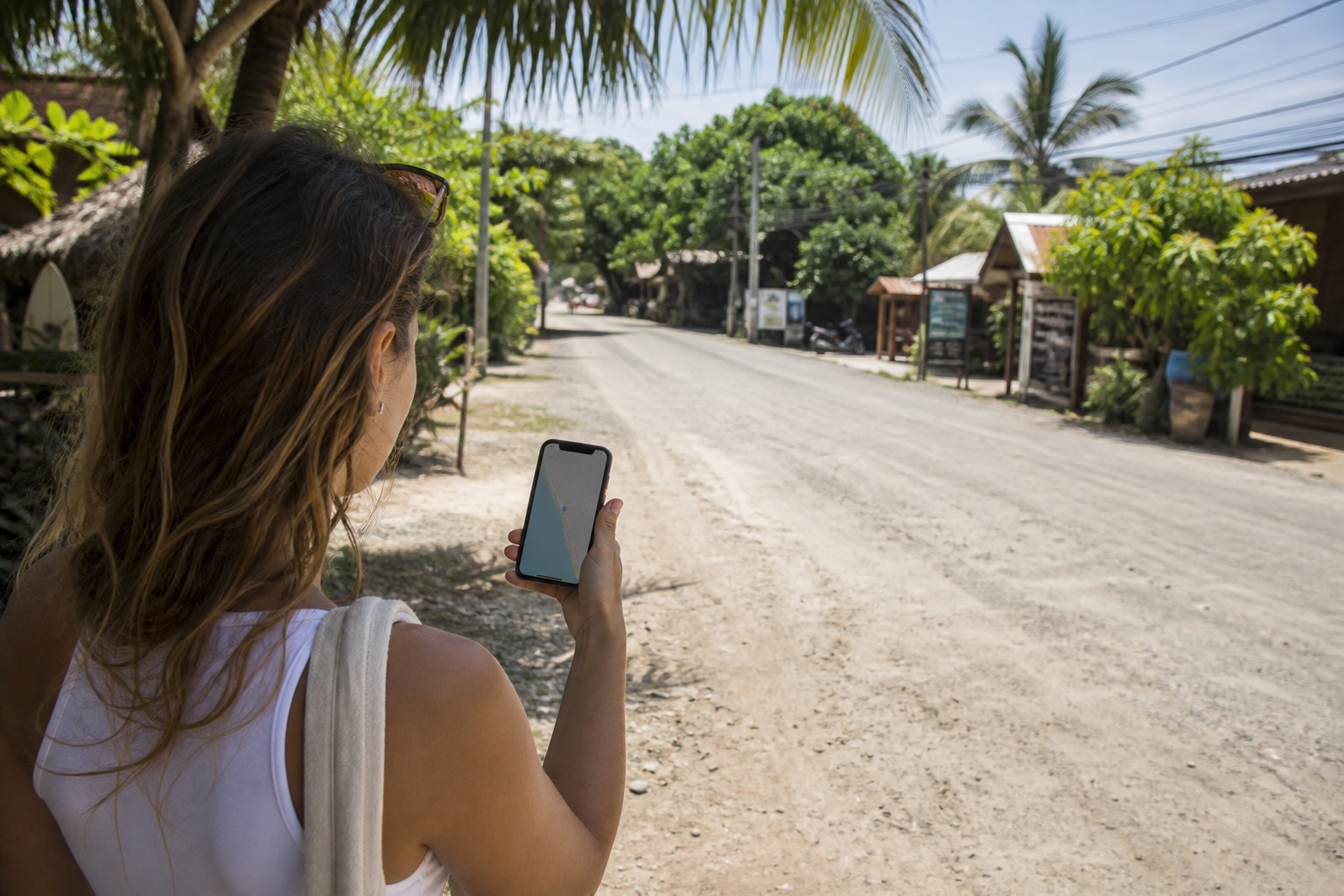 Traveler checking a ride app on an empty road in Santa Teresa Costa Rica