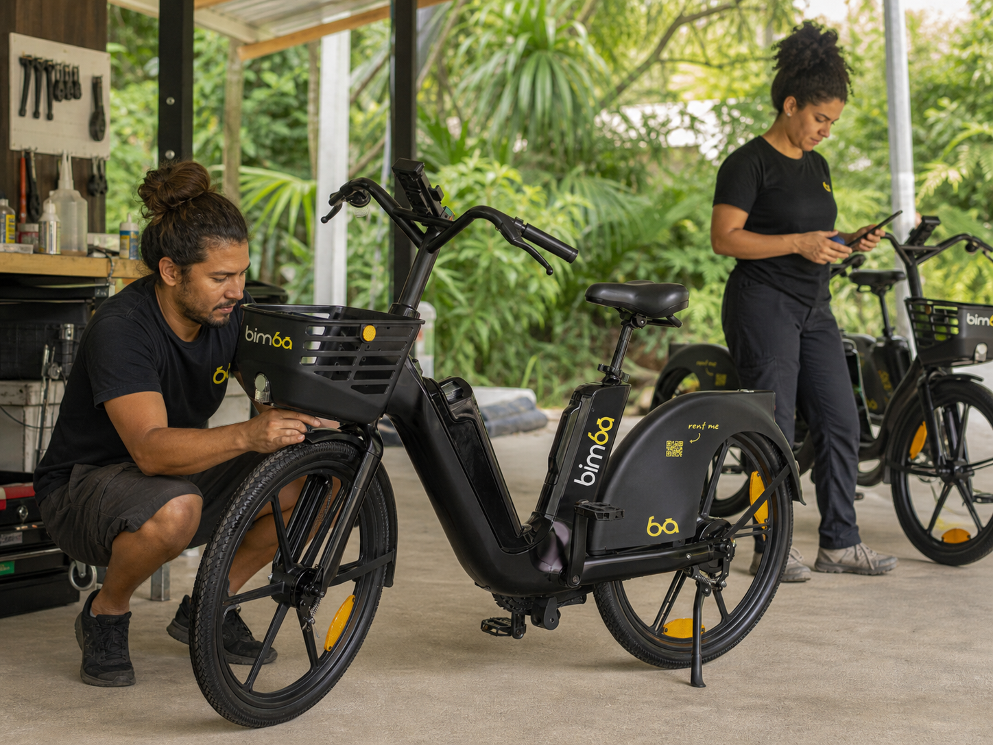 Two local Bimba team members inspecting electric bikes and preparing the fleet for riders