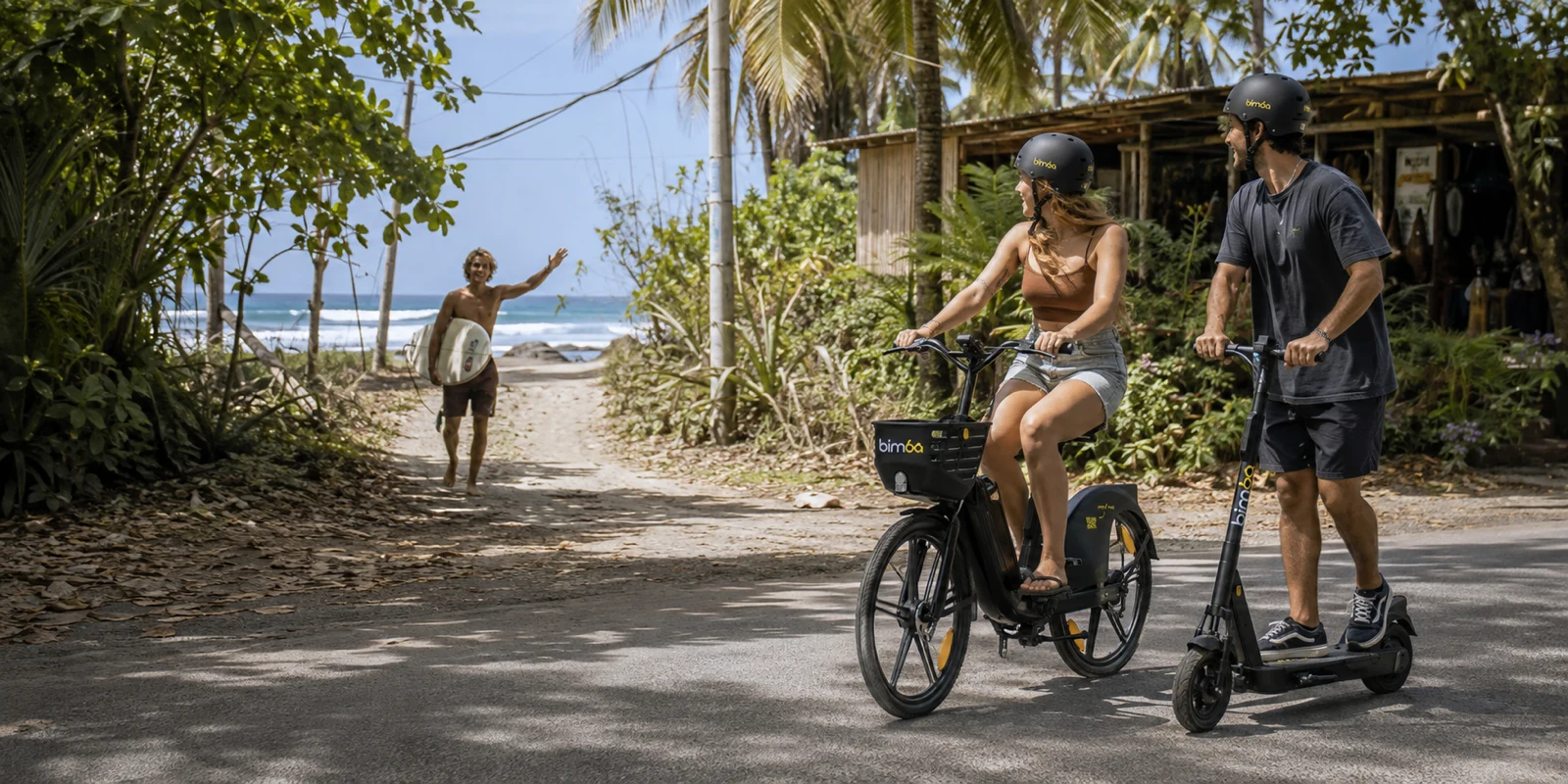 Friends riding Bimba electric bikes and scooters toward the beach in Santa Teresa, Costa Rica