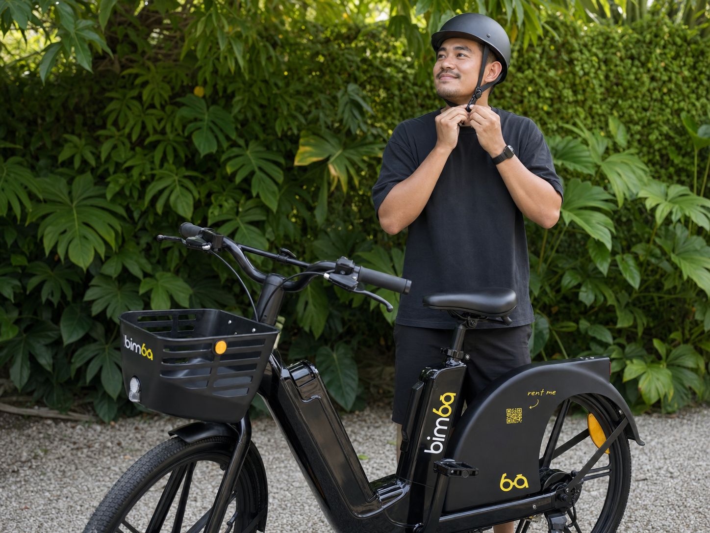 Bimba rider fastening a properly fitted helmet beside a stationary e-bike