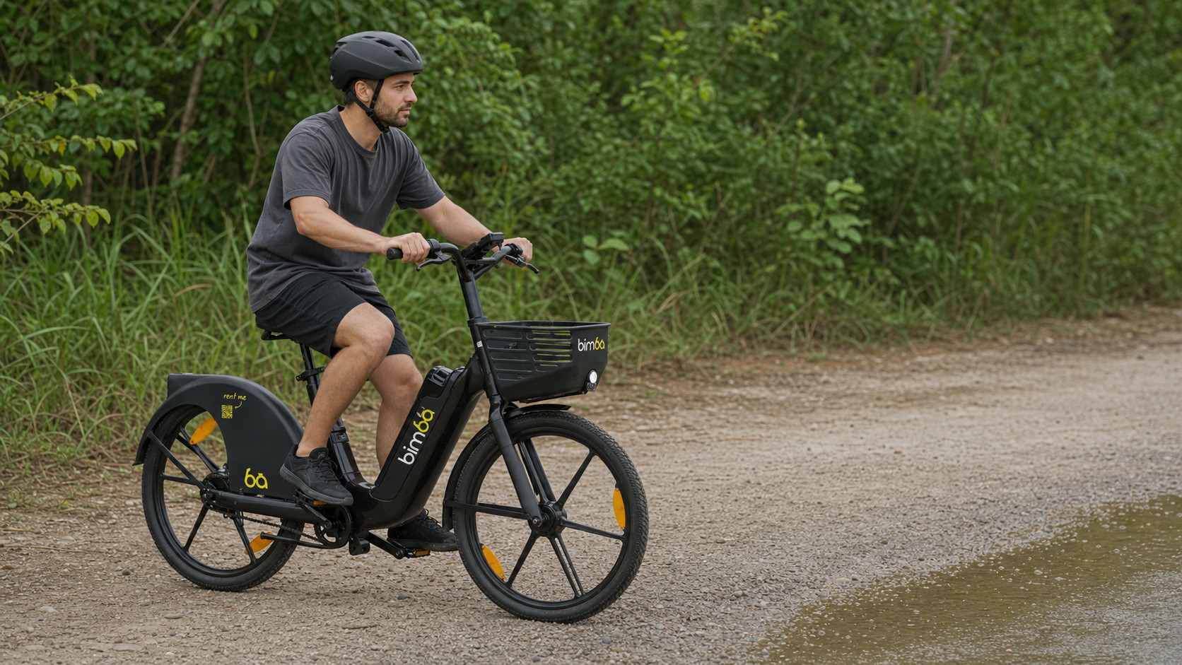 Helmeted Bimba rider slowing before a wet section on a gravel road